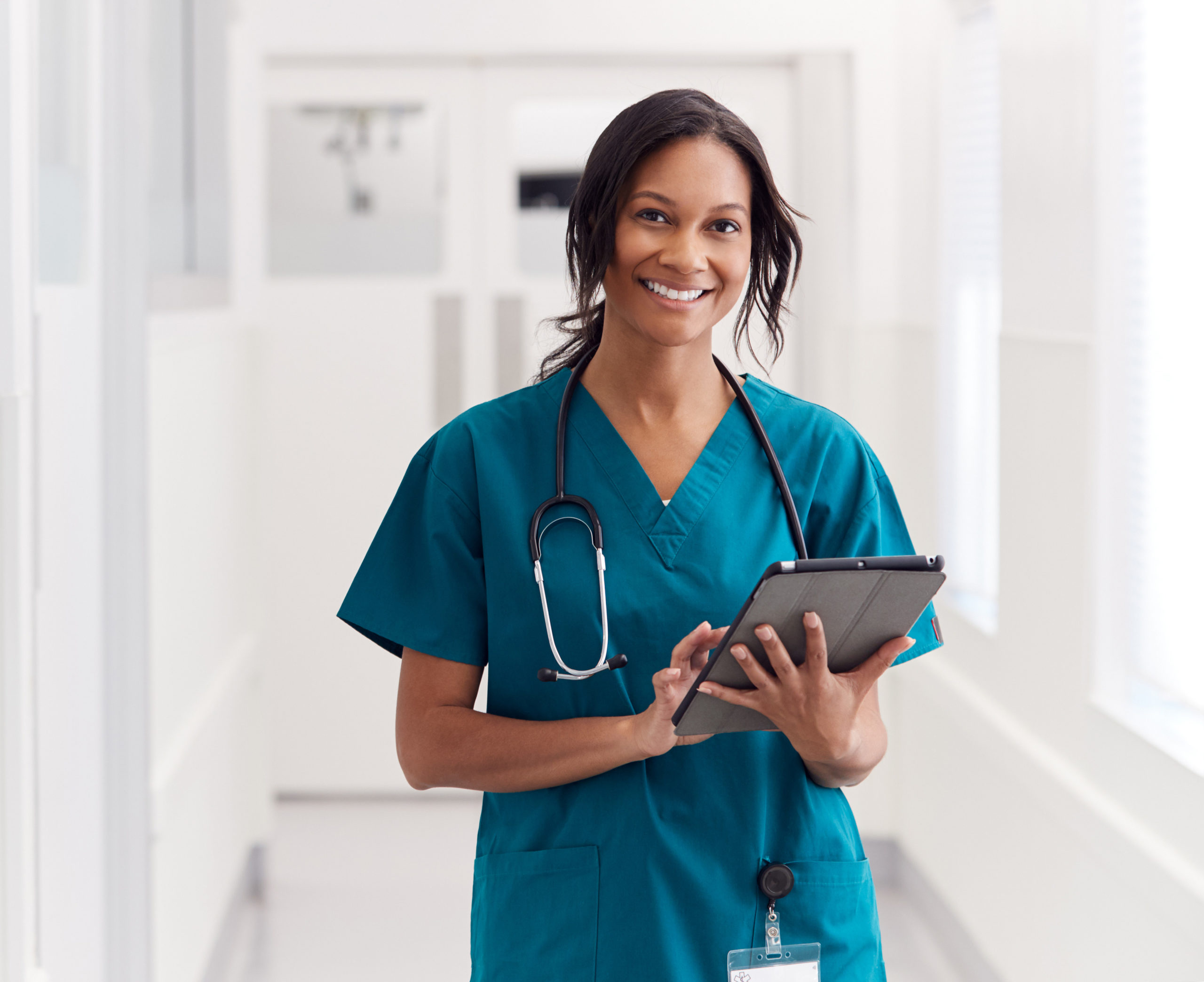 a smiling nurse with a tablet