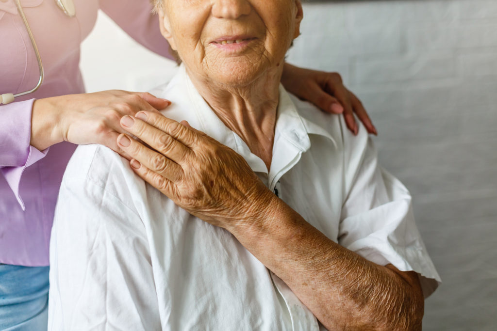 a doctor with hand on happy elderly patient